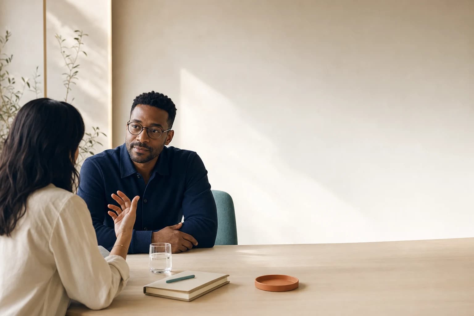 Two professionals in a focused conversation at a meeting table